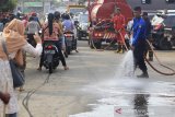 Petugas membersihkan jalan dengan air saat kegiatan Sosialisasi dan kebersihan di Pasar baru, Indramayu, Jawa Barat, Sabtu (14/3/2020). Kegiatan Sosialisasi dan Bersih-Bersih tersebut sebagai upaya pencegahan penyebaran virus COVID-19 khususnya di area umum. ANTARA JABAR/Dedhez Anggara/agr