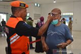 Petugas melakukan pemeriksaan suhu tubuh penumpang di Stasiun Jombang, Jawa Timur, Minggu (15/3/2020). PT Kereta Api Indonesia Daop 7 Madiun memeriksa seluruh penumpang, pegawai dan petugas kebersihan yang akan masuk ke stasiun serta menyediakan hand sanitizer untuk mencegah penyebaran virus corona atau covid-19. Antara Jatim/Syaiful Arif/zk