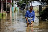 Warga melintasi banjir yang melanda Kampung Bojongasih, Dayeuhkolot, Kabupaten Bandung, Jawa Barat, Senin (16/3/2020). Banjir luapan Sungai Citarum setinggi 30 sentimeter hingga 1 meter kembali merendam kawasan tersebut akibat hujan deras yang melanda Bandung Raya pada Minggu (15/3) sore hingga malam hari. ANTARA JABAR/Raisan Al Farisi/agr