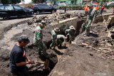 Tim gabungan yang terdiri dari TNI-Polri, BPBD dan warga membersihkan saluran air dampak banjir bandang di Sempol, Ijen, Bondowoso, Jawa Timur, Minggu (15/3/2020). Untuk mengantisipasi terjadinya banjir bandang susulan, tim gabungan fokus melakukan pembersihan saluran air yang tersumbat karena curah hujan masih tinggi. Antara Jatim/Budi Candra Setya/zk.