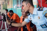 Petugas membantu warga binaan memanfaatkan fasilitas panggilan video di Lapas Kelas II B Blitar, Jawa Timur, Senin (17/3/2020). Lapas Kelas II B Blitar menutup sementara akses kunjungan terhadap keluarga narapidana hingga 14 hari kedepan dan menggantikanya dengan memberikan fasilitas panggilan video, guna mengantisipasi dan pencegahan penyebaran COVID-19 dilingkungan Lapas. Antara Jatim/Irfan Anshori/zk.