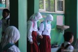 Siswa menggunakan masker saat akan pulang di SDN Lawangan Daya 2, Pamekasan, Jawa Timur, Selasa (17/3/2020). Berdasarkan surat edaran bupati setempat kegiatan pembelajaran siswa PAUD/TK, SD SMP dan SMA secara mandiri dilaksanakan di rumah masing masing terhitung mulai tanggal 18 Maret hingga 2 April, terkait pandemi COVID-19. Antara Jatim/Saiful Bahri/zk.