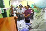 Wali Kota Banjarmasin Ibnu Sina (dua kanan) melihat pembuatan cairan antiseptik atau hand sanitizer di Laboratorium SMK ISFI Banjarmasin, Kalimantan Selatan, Rabu (18/3/2020). Siswa SMK ISFI Banjarmasin memproduksi cairan antiseptik pembersih tangan sebagai antisipasi untuk pencegahan penyebaran virus COVID-19 yang dijual seharga Rp20.000 per botol ukuran 20 mililiter dan Rp25.000 per botol ukuran 100 mililiter. Foto Antaranews Kalsel/Bayu Pratama S.