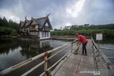 Petugas membersihkan dermaga di Wisata Alam Floating Market, Lembang, Kabupaten Bandung Barat, Jawa Barat, Kamis (19/3/2020). Mulai hari ini, Kamis (19/3) Pemerintah Kabupaten Bandung Barat meminta agar pengelola kawasan wisata menutup usahanya selama dua minggu guna mengantisipasi kerumunan wisatawan yang berpotensi dapat memperluas penyebaran COVID-19 di Jawa Barat. ANTARA JABAR/Raisan Al Farisi/agr