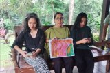 Pasein COVID-19 yang telah sembuh Maria Darmaningsih (tengah) memperlihatkan lukisan hasil karyanya selama diisolasi di RSPI Sulianti Saroso.