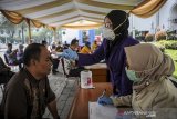 Petugas kesehatan memeriksa suhu tubuh seorang ASN saat screening ASN di Kompleks Gedung Sate, Bandung, Jawa Barat, Jumat (20/3/2020). Pemerintah Provinsi Jawa Barat melakukan screening terhadap seluruh ASN yang bekerja di Komplek Pemerintahan Gedung Sate guna mengantisipasi penyebaran COVID-19 pasca salah seorang ASN yang positif COVID-19. ANTARA JABAR/Raisan Al Farisi/agr