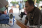 Petugas kesehatan menunjukan suhu tubuh seorang ASN saat screening ASN di Kompleks Gedung Sate, Bandung, Jawa Barat, Jumat (20/3/2020). Pemerintah Provinsi Jawa Barat melakukan screening terhadap seluruh ASN yang bekerja di Komplek Pemerintahan Gedung Sate guna mengantisipasi penyebaran COVID-19 pasca salah seorang ASN yang positif COVID-19. ANTARA JABAR/Raisan Al Farisi/agr