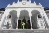 Personil kepolisian Polda Aceh dari jajaran Polresta Banda Aceh, Satuan Brimob dan Bid Dokkes melakukan penyemprotan cairan desinfektan di Masjid Raya Baiturrahman, Banda Aceh, Aceh, Jumat (20/3/2020). Penyemprotan disinfektan yang dilakukan sebelum pelaksanaan ibadah salat jumat itu guna mencegah penularan virus Corona 2019 (COVID-19). Antara Aceh/Irwansyah Putra.