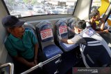 Petugas Dinas Perhubungan menempel striker larangan duduk jarak sosial (Social Distancing) di kursi bus trans kutaraja, Banda Aceh, Aceh, Jumat (20/3/2020). Dinas perhubungan Provinsi Aceh menerapkan social distancing di halte dan bus trans kutaraja sebagai upaya mencegah potensi penyebaran virus Corona  (COVID-19). Antara Aceh/irwansyah Putra.