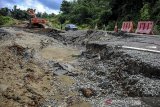 Pekerja menggunakan alat berat menyelesaikan proses perbaikan jalan yang ambles di Lingkar Timur Jatigede, Wado, Kabupaten Sumedang, Jawa Barat, Sabtu (21/3/2020). Pemerintah setempat menyatakan, bencana jalan ambles pada jalan yang menghubungkan Kabupaten Sumedang dan Kabupaten Tasikmalaya tersebut disebabkan oleh kontur tanah yang labil serta curah hujan yang tinggi di kawasan tersebut beberapa hari terakhir ini. ANTARA JABAR/Raisan Al Farisi/agr