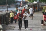 Warga menggunakan masker melintas di kawasan Siring Menara Pandang, Banjarmasin, Kalimantan Selatan, Sabtu (21/3/2020). Pemerintah Provinsi Kalimantan Selatan menaikkan status dari siaga darurat menjadi tanggap darurat COVID-19, naiknya status tersebut akibat dua Provinsi tetangga yaitu Kalimantan Timur dan Kalimantan Tengah telah ditemukan pasien positif COVID-19 dan akan melakukan cegah tangkal di daerah perbatasan khususnya di darat dan sungai. Foto Antaranews Kalsel/Bayu Pratama S.