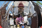 Dua orang anak berada di dekat Ogoh-ogoh yang dibuat menjelang Hari Raya Nyepi Tahun Saka 1942 di Denpasar, Bali, Minggu (22/3/2020). Gubernur Bali Wayan Koster menginstruksikan larangan pelaksanaan pengarakan Ogoh-ogoh dalam bentuk apapun yang berpotensi menimbulkan keramaian dan kerumuman orang di seluruh wilayah Bali sebagai upaya pencegahan penyebaran COVID-19. ANTARA FOTO/Fikri Yusuf/nym