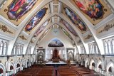Petugas keamanan gereja melintas diantara kursi kosong di Gereja Katolik Santo Yakobus Surabaya, Jawa Timur, Minggu (22/3/2020). Keuskupan Surabaya memutuskan meniadakan misa atau pun semua kegiatan yang melibatkan banyak umat Katolik untuk mengantisipasi persebaran virus corona (COVID-19). Antara Jatim/Zabur Karuru