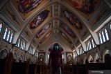 Petugas keamanan gereja melintas diantara kursi kosong di Gereja Katolik Santo Yakobus Surabaya, Jawa Timur, Minggu (22/3/2020). Keuskupan Surabaya memutuskan meniadakan misa atau pun semua kegiatan yang melibatkan banyak umat Katolik untuk mengantisipasi persebaran virus corona (COVID-19).  Antara Jatim/Zabur Karuru