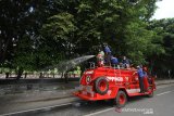 Petugas Damkar menyemprotkan cairan disinfektan di jalan Kapten Piere Tandean kawasan Siring Menara Pandang, Banjarmasin, Kalimantan Selatan, Senin (23/3/2020). Penyemprotan cairan disinfektan serentak di kota Banjarmasin tersebut sebagai salah satu upaya antisipasi penyebaran virus COVID-19 mengingat telah ditemukannya satu kasus positif di Kalimantan Selatan. Foto Antaranews Kalsel/Bayu Pratama S.