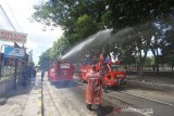 Petugas Damkar menyemprotkan cairan disinfektan di jalan Kapten Piere Tandean kawasan Siring Menara Pandang, Banjarmasin, Kalimantan Selatan, Senin (23/3/2020). Penyemprotan cairan disinfektan serentak di kota Banjarmasin tersebut sebagai salah satu upaya antisipasi penyebaran virus COVID-19 mengingat telah ditemukannya satu kasus positif di Kalimantan Selatan. Foto Antaranews Kalsel/Bayu Pratama S.