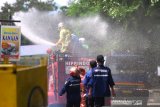 Petugas Damkar menyemprotkan cairan disinfektan di jalan Kapten Piere Tandean kawasan Siring Menara Pandang, Banjarmasin, Kalimantan Selatan, Senin (23/3/2020). Penyemprotan cairan disinfektan serentak di kota Banjarmasin tersebut sebagai salah satu upaya antisipasi penyebaran virus COVID-19 mengingat telah ditemukannya satu kasus positif di Kalimantan Selatan. Foto Antaranews Kalsel/Bayu Pratama S.