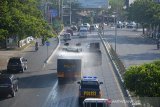 Mobil Tanki Polda Aceh menyemprotan cairan disinfektan di lintasan jalan utama kawasan Lamprit, Banda Aceh, Aceh, Senin (23/3/2020). Penyemprotan cairan disinfektan sepanjang jalan utama dan termasuk kendaraan itu dalam upaya mencegah penyeberan virus COVID-19. Antara Aceh/Ampelsa.