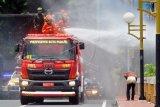 Petugas pemadam kebakaran menyemprotkan cairan disinfektan ke fasilitas umum di Padang, Sumatera Barat, Senin (23/3/2020). Tim gabungan terdiri dari TNI-Polri, BPBD, Satpol-PP dan Pemadam Kebakaran melakukan penyemprotan disinfektan secara massal di jalan protokol dan fasilitas umum di kota itu untuk mengantisipasi penyebaran COVID-19. ANTARA FOTO/Iggoy el Fitra/aww.