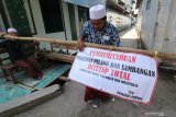 Petugas menjaga salah satu gerbang keluar masuk kawasan Pondok Pesantren (ponpes) Lirboyo, di Kota Kediri, Jawa Timur, Selasa (24/3/2020). Ponpes terbesar se-Jawa Timur tersebut membatasi akses keluar-masuk bagi santri maupun keluarga satri hingga batas waktu yang belum ditentukan guna menangkal penyebaran COVID-19. Antara Jatim/Prasetia Fauzani/zk.