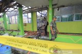 Personel Polisi dan TNI sekolah memeriksa sisa kebakaran di SMP 2 Indramayu, Jawa Barat, Rabu (25/3/2020). Kebakaran yang menghanguskan lima ruangan sekolah dan dokumen-dokumen penting di sekolah tersebut diduga akibat arus pendek listrik. ANTARA JABAR/Dedhez Anggara/agr