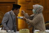 Salah satu pasangan pengantin, Diana Anggraini (kanan) menyuapkan makanan kepada suaminya Amal Fatchullah (kiri) disela-sela acara resepsi pernikahannya di Gedung Negara Grahadi, Surabaya, Jawa Timur, Rabu (25/3/2020). Gubernur Jawa Timur Khofifah Indar Parawansa menggelar resepsi pernikahan dua pasang pengantin Yavuz Ozdemir-Irra Chorina Octora serta Amal Fatchullah-Diana Anggraini yang hanya dihadiri pihak keluarga mempelai guna menghindari pertemuan dengan orang banyak dan meminimalkan penyebaran COVID-19. Antara Jatim/Moch Asim/zk.