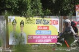 Pengendara melintas dengan latar belakang himbauan untuk mencegah virus COVID-19 di jalan Sultan Adam, Banjarmasin, Kalimantan Selatan, Kamis (26/3/2020). Pemerintah Provinsi Kalimantan Selatan memasang spanduk himbauan pencegahan penyebaran virus COVID-19 di sejumlah daerah di Provinsi Kalimantan Selatan. Foto Antaranews Kalsel/Bayu Pratama S.