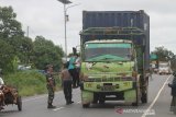 Petugas melakukan pemeriksaan suhu tubuh pengendara di jalan Trans Kalimantan , Kabupaten Barito Kuala, Kalimantan Selatan, Jumat (27/3/2020). Pemerintah Provinsi Kalimantan Selatan melakukan upaya pencegahan penyebaran virus COVID-19 dengan membentuk tim gabungan terdiri dari BPBD, petugas kesehatan, TNI dan Polri untuk melakukan pemberhentian kendaraan serta pemeriksaan suhu tubuh pengendara maupun penumpang yang memasuki Daerah Provinsi Kalimantan Selatan di perbatasan Provinsi Kalsel-Kalteng. Foto Antaranews Kalsel/Bayu Pratama S.