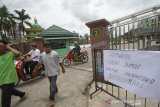 Warga melintas di kawasan Masjid Jami Banjarmasin, Kalimantan Selatan, Jumat (27/3/2020). Majelis Ulama Indonesia (MUI) Provinsi Kalimantan Selatan mengeluarkan himbauan meniadakan penyelenggaraan shalat jumat di masjid-masjid dan menggantikannya dengan melaksanakan shalat zuhur di rumah masing-masing, mengingat telah ditemukannya satu pasien positif COVID-19 di Provinsi Kalimantan Selatan. Foto Antaranews Kalsel/Bayu Pratama S.