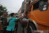 Petugas melakukan pemeriksaan suhu tubuh pengendara di jalan Trans Kalimantan , Kabupaten Barito Kuala, Kalimantan Selatan, Jumat (27/3/2020). Pemerintah Provinsi Kalimantan Selatan melakukan upaya pencegahan penyebaran virus COVID-19 dengan membentuk tim gabungan terdiri dari BPBD, petugas kesehatan, TNI dan Polri untuk melakukan pemberhentian kendaraan serta pemeriksaan suhu tubuh pengendara maupun penumpang yang memasuki Daerah Provinsi Kalimantan Selatan di perbatasan Provinsi Kalsel-Kalteng. Foto Antaranews Kalsel/Bayu Pratama S.