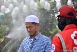 Petugas Palang Merah Indonesia (PMI) Kota Madiun menyemprotkan cairan disinfektan pada umat muslim yang akan melaksanakan Ibadah shalat Jumat di Masjid Agung Baitul Hakim, Kota Madiun, Jawa Timur, Jumat (27/3/2020). Penyemprotan tersebut dimaksudkan untu pencegahan penyebaran COVID-19 atau virus Corona. Antara Jatim/Siswowidodo/zk.