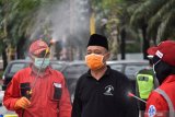 Petugas Palang Merah Indonesia (PMI) Kota Madiun menyemprotkan cairan disinfektan pada umat muslim yang akan melaksanakan Ibadah shalat Jumat di Masjid Agung Baitul Hakim, Kota Madiun, Jawa Timur, Jumat (27/3/2020). Penyemprotan tersebut dimaksudkan untu pencegahan penyebaran COVID-19 atau virus Corona. Antara Jatim/Siswowidodo/zk.