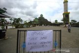 Pengumuman peniadaan shalat jumat terpampang di depan Masjid Jami Banjarmasin, Kalimantan Selatan, Jumat (27/3/2020). Majelis Ulama Indonesia (MUI) Provinsi Kalimantan Selatan mengeluarkan himbauan meniadakan penyelenggaraan shalat jumat di masjid-masjid dan menggantikannya dengan melaksanakan shalat zuhur di rumah masing-masing, mengingat telah ditemukannya satu pasien positif COVID-19 di Provinsi Kalimantan Selatan. Foto Antaranews Kalsel/Bayu Pratama S.