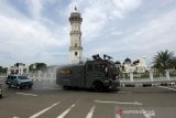 Personil Polda Aceh melakukan penyemprotan cairan disinfektan dengan meggunakan mobil water canon di jalan depan Masjid Raya Baiturrahman, Banda Aceh; Aceh; Jumat (27/3/2020). Kodam Iskandar Muda dan Polda Aceh mengerahkan; personil dan armada untuk melakukan sosialisasi dan pencegahan penularan virus Corona (COVID-19). Antara Aceh/Irwansyah Putra.