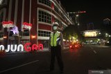 Polisi berjaga di Jalan Tunjungan, Surabaya, Jawa Timur, Jumat (27/3/2020) malam. Polrestabes Surabaya memberlakukan kawasan tertib 'physical distancing' atau jaga jarak secara fisik di Jalan Tunjungan dan Jalan Raya Darmo pada hari Jumat, Sabtu dan Minggu di jam tertentu dengan tidak memperbolehkan kendaraan melintas atau orang berkumpul di kawasan tersebut guna mencegah penyebaran virus Corona atau COVID-19. Antara Jatim/didik/Zk