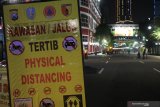 Polisi berjaga di Jalan Tunjungan, Surabaya, Jawa Timur, Jumat (27/3/2020) malam. Polrestabes Surabaya memberlakukan kawasan tertib 'physical distancing' atau jaga jarak secara fisik di Jalan Tunjungan dan Jalan Raya Darmo pada hari Jumat, Sabtu dan Minggu di jam tertentu dengan tidak memperbolehkan kendaraan melintas atau orang berkumpul di kawasan tersebut guna mencegah penyebaran virus Corona atau COVID-19. Antara Jatim/didik/Zk