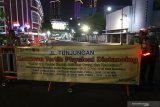Polisi memasang spanduk informasi penutupan jalan di Jalan Tunjungan, Surabaya, Jawa Timur, Jumat (27/3/2020) malam. Polrestabes Surabaya memberlakukan kawasan tertib 'physical distancing' atau jaga jarak secara fisik di Jalan Tunjungan dan Jalan Raya Darmo pada hari Jumat, Sabtu dan Minggu di jam tertentu dengan tidak memperbolehkan kendaraan melintas atau orang berkumpul di kawasan tersebut guna mencegah penyebaran virus Corona atau COVID-19. Antara Jatim/didik/Zk
