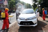 Petugas BPBD menyemprotkan cairan desinfektan ke sejumlah kendaraan di Jalan Lintas Blitar-Malang di Blitar, Jawa Timur, Sabtu (28/3/2020). Selain melakukan penyekatan dan pembatasan kendaraan yang hendak keluar-masuk, Petugas Gabungan dari Gugus Tugas Percepatan Penanganan Virus Corona (COVID-19) Kabupaten Blitar juga melarang sejumlah kendaraan dari daerah lain yang tidak memiliki kepentingan untuk memasuki kawasan Blitar, Guna menekan penyebaran COVID-19. Antara Jatim/Irfan Anshori/zk