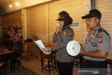 Anggota Polres Gorontalo Kota memberikan imbauan kepada warga saat patroli kepatuhan di Kota Gorontalo. Patroli tersebut dilakukan untuk meminta masyarakat agar tidak berkumpul dan melakukan aktivitas diluar rumah dalam keramaian untuk meredam penyebaran COVID-19 dimana saat ini Gorontalo telah ditetapkan siaga darurat bencana non-alam. (ANTARA FOTO/Adiwinata Solihin)