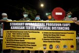 Plt Walikota Blitar Santoso (ketiga kiri) didampingi Dandim 0808/Blitar Letkol Inf Krisbianto (Dua Kiri) dan Kapolres Blitar Kota AKBP Leonard Sinambela memasang spanduk kawasan tertib Pembatasan Sosial (Physical Distancing) di salah satu kawasan pemukiman di Blitar, Jawa Timur, Sabtu (28/3/2020) malam. Selain mulai menerapkan kawasan Physical Distancing, Polres Blitar Kota besserte Pemda setempat juga melakukan penutupan sejumlah jalan protokoler guna mencegah penyebaran COVID-19 di daerah itu. Antara Jatim/Irfan Anshori/zk.