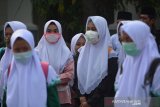 Santriwati menuju ke dalam bus saat dipulangkan dari Pondok Pesantren Bahrul Ulum Tambakberas, Jombang, Jawa Timur, Sabtu (28/3/2020). Berbagai pondok pesantren di Jombang memilih memulangkan santri-santri ke daerah asalnya secara bertahap untuk mencegah persebaran virus COVID-19. Antara Jatim/Syaiful Arif/zk.