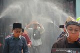 Santri disemprot cairan disinfektan sebelum masuk ke dalam bus di Pondok Pesantren Bahrul Ulum Tambakberas, Jombang, Jawa Timur, Sabtu (28/3/2020). Berbagai pondok pesantren di Jombang memilih memulangkan santri-santri ke daerah asalnya secara bertahap untuk mencegah persebaran virus COVID-19. Antara Jatim/Syaiful Arif/zk.