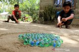 Sejumlah anak bermain kelereng di halaman rumahnya di Desa Alue Raya, Kecamatan Samatiga, Aceh Barat, Aceh, Senin (30/3/2020). Permainan tradisional yang populer di era 1980-an ini semakin jarang dimainkan anak-anak seiring maraknya permainan-permainan modern berteknologi canggih. Antara Aceh/Syifa Yulinnas.