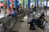 Sejumlah penumpang menunggu keberangkatan di Terminal Mengwi, Badung, Bali, Senin (30/3/2020). Suasana di terminal tersebut lebih lengang dari biasanya terkait imbauan Gubernur Bali untuk membatasi atau menunda perjalanan dari dan ke Bali untuk mengurangi interaksi antar individu maupun kelompok masyarakat dalam upaya pencegahan penyebaran COVID-19. ANTARA FOTO/Nyoman Hendra Wibowo/nym