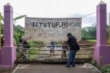 Warga menutup salah satu pintu masuk di Desa Sampih, Wonopringgo, Kabupaten Pekalongan, Jawa Tengah, Senin (30/3/20). Sejumlah desa di Kabupaten Pekalongan mulai memberlakukan akses satu pintu masuk utama dan menutup pintu lainnya serta mewajibkan warga yang datang di cek suhu badan serta disemprot cairan disinfektan untuk mencegah menyebarnya virus Corona (COVID-19). ANTARA FOTO/Harviyan Perdana Putra/aww.