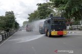 Polisi menyemprotkan cairan disinfektan di jalan Ahmad Yani, Banjarmasin, Kalimantan Selatan, Selasa (31/3/2020). POLRI bersama TNI dan Pemerintah Kota Banjarmasin terus berupaya melakukan pencegahan penyebaran virus COVID-19 dengan menyemprotkan caoran disinfektan serentak di jalan protokol dan tempat-tempat umum di Kota Banjarmasin. Foto Antaranews Kalsel/HO/Kodim 1007/Bay.