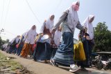 Sejumlah santriawati berjalan menuju bus untuk dipulangkan ke daerah asal di Pondok Pesantren (ponpes) Lirboyo, Kota Kediri, Jawa Timur, Selasa (31/3/2020). Ponpes terbesar se-Jawa Timur tersebut memulangkan sedikitnya 22 ribu santri untuk menangkal penyebaran COVID-19. Antara Jatim/Prasetia Fauzani/zk