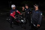 Petugas keamanan adat memeriksa pengendara sepeda motor saat hendak melintas di jalan Kelurahan Panjer, Denpasar, Bali, Rabu (1/4/2020). Petugas adat di kawasan itu membatasi mobilitas orang masuk ke wilayah tersebut mulai pukul 19.00 - 24.00 wita yang diberlakukan 31 Maret hingga 7 April 2020 untuk mencegah penyebaran COVID-19. ANTARA FOTO/Nyoman Hendra Wibowo/nym.