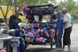 Pedagang melayani pembeli berbelanja sandal di terminal Pelabuhan Perikanan Desa Lampulo, Banda Aceh, Aceh, Rabu (1/4/2020). Dampak penerapan jam malam dan sejumlah pusat pasar tutup untuk mencegah penyebaran virus Corona (COVID-19), beberapa pedagang memilih alternatif memasarkan barang dagangannya berkeliling hingga ke pinggiran kota. Antara Aceh/Ampelsa