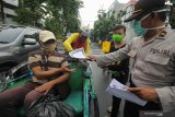 Polisi memberikan imbauan dan penyemprotan kepada pengemudi ojek daring di Jalan Bubutan, Surabaya, Jawa Timur, Jumat (3/4/2020). Kegiatan imbauan menghindari keramaian, penyemprotan disinfektan serta pemberian nasi bungkus yang dilakukan oleh pihak kepolisian bersama suporter sepak bola tersebut untuk mencegah penyebaran Virus Corona (COVID-19) dan meringankan beban ekonomi para pengemudi ojek daring. Antara Jatim/Didik/Zk